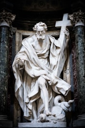 A marble statue of a man holding a cross.