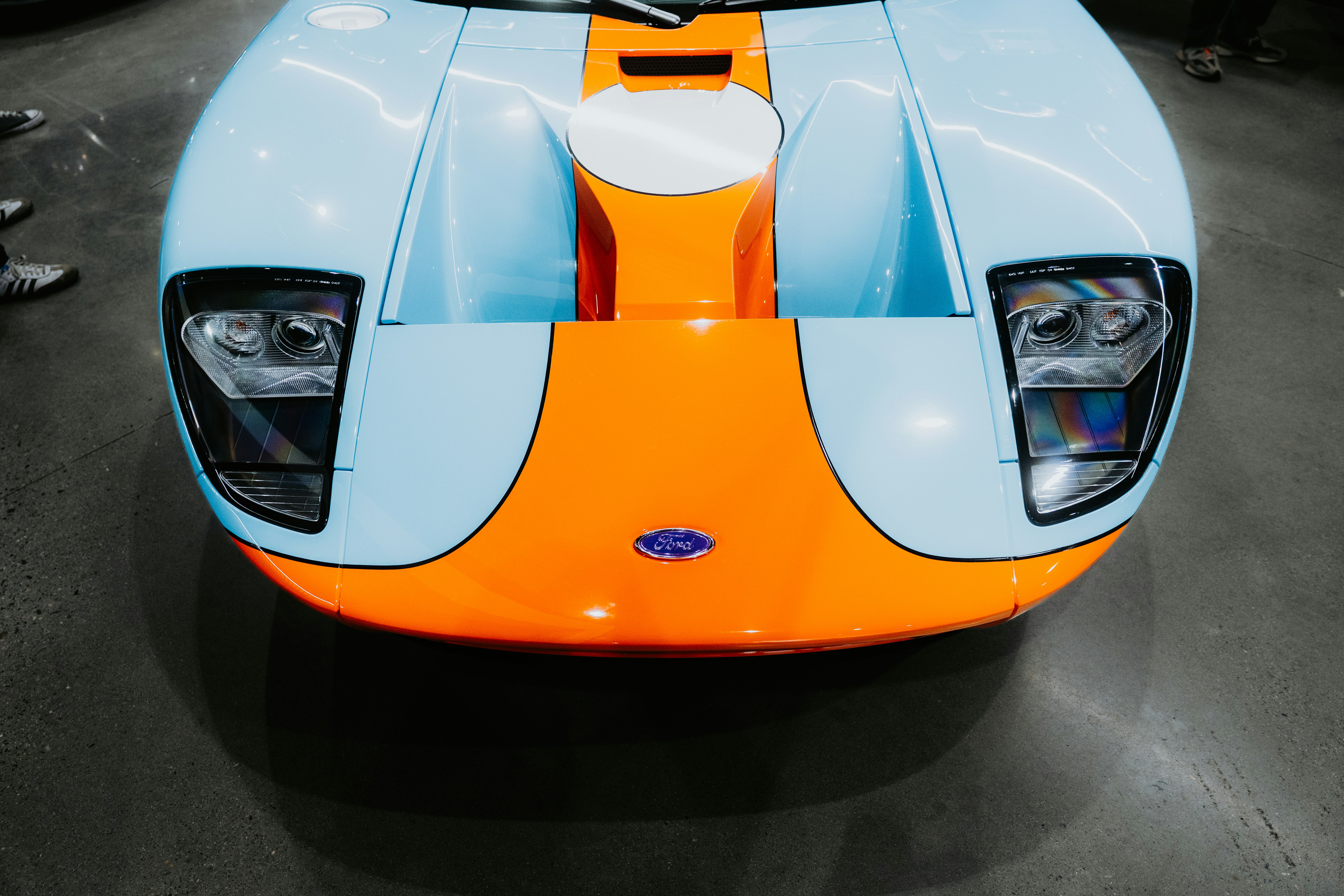 ショールームに展示されているブルーとオレンジのフォードGT。の写真
