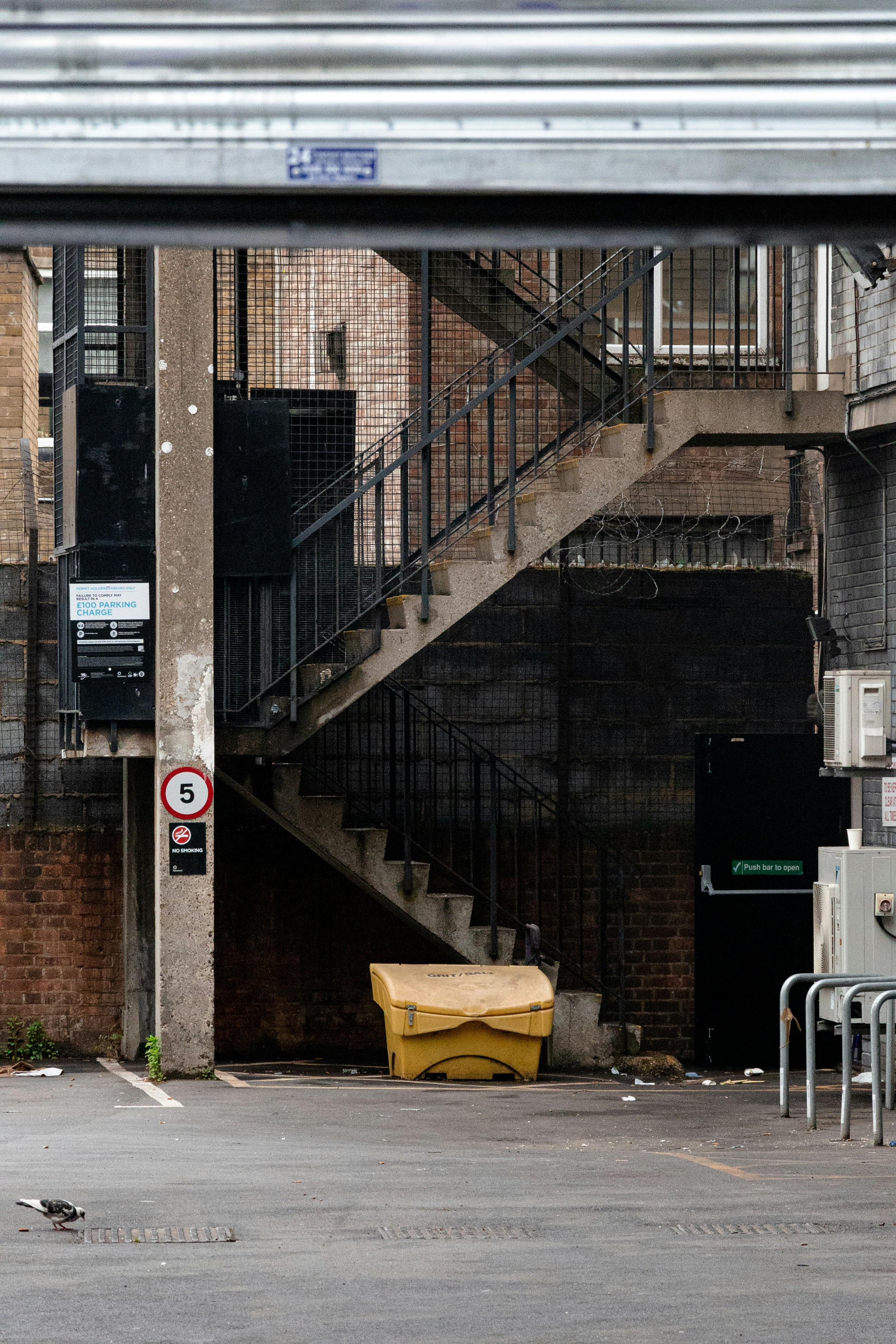 An outdoor staircase is visible in an urban alley.