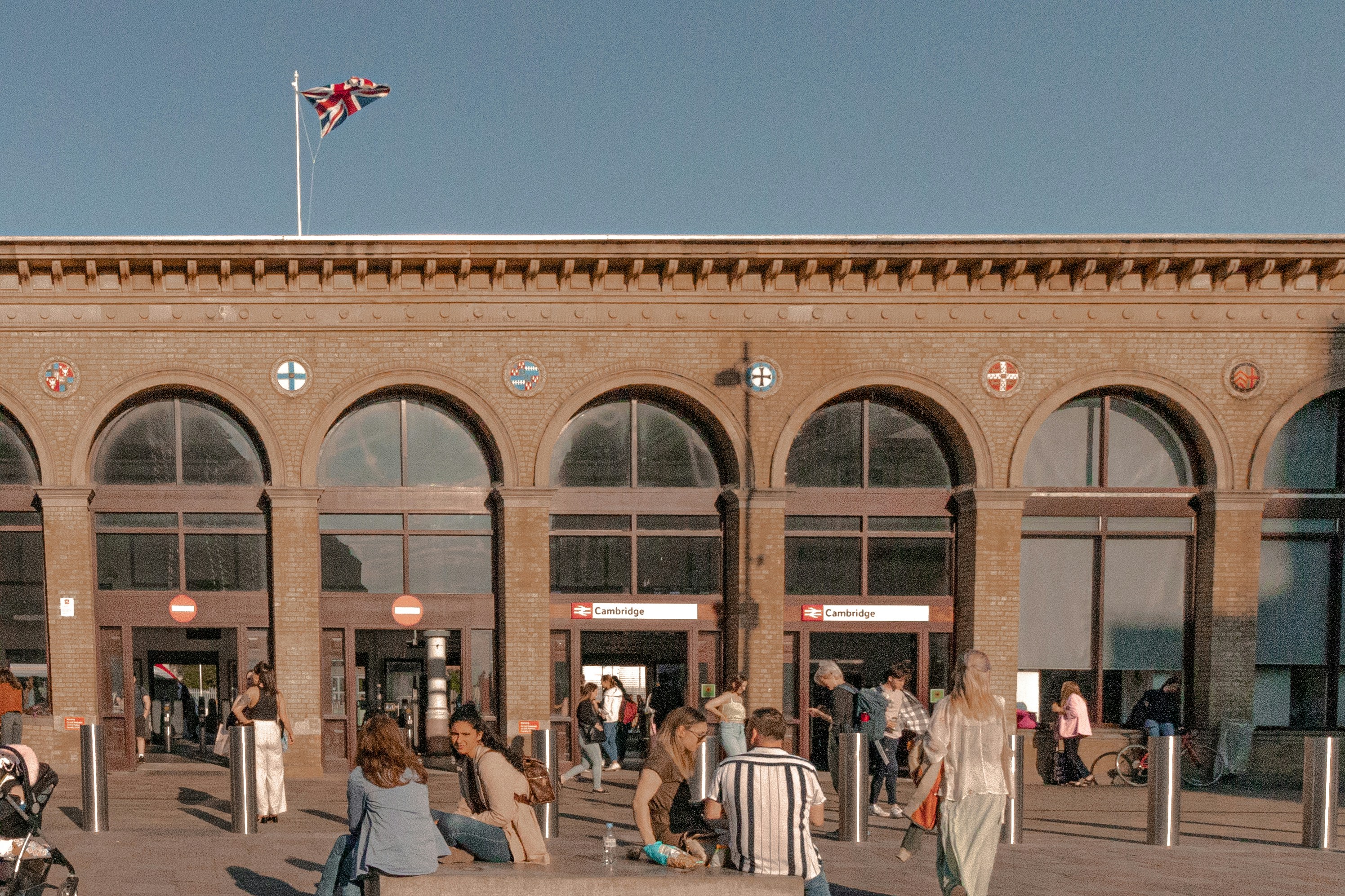 A train station with people and a british flag.
