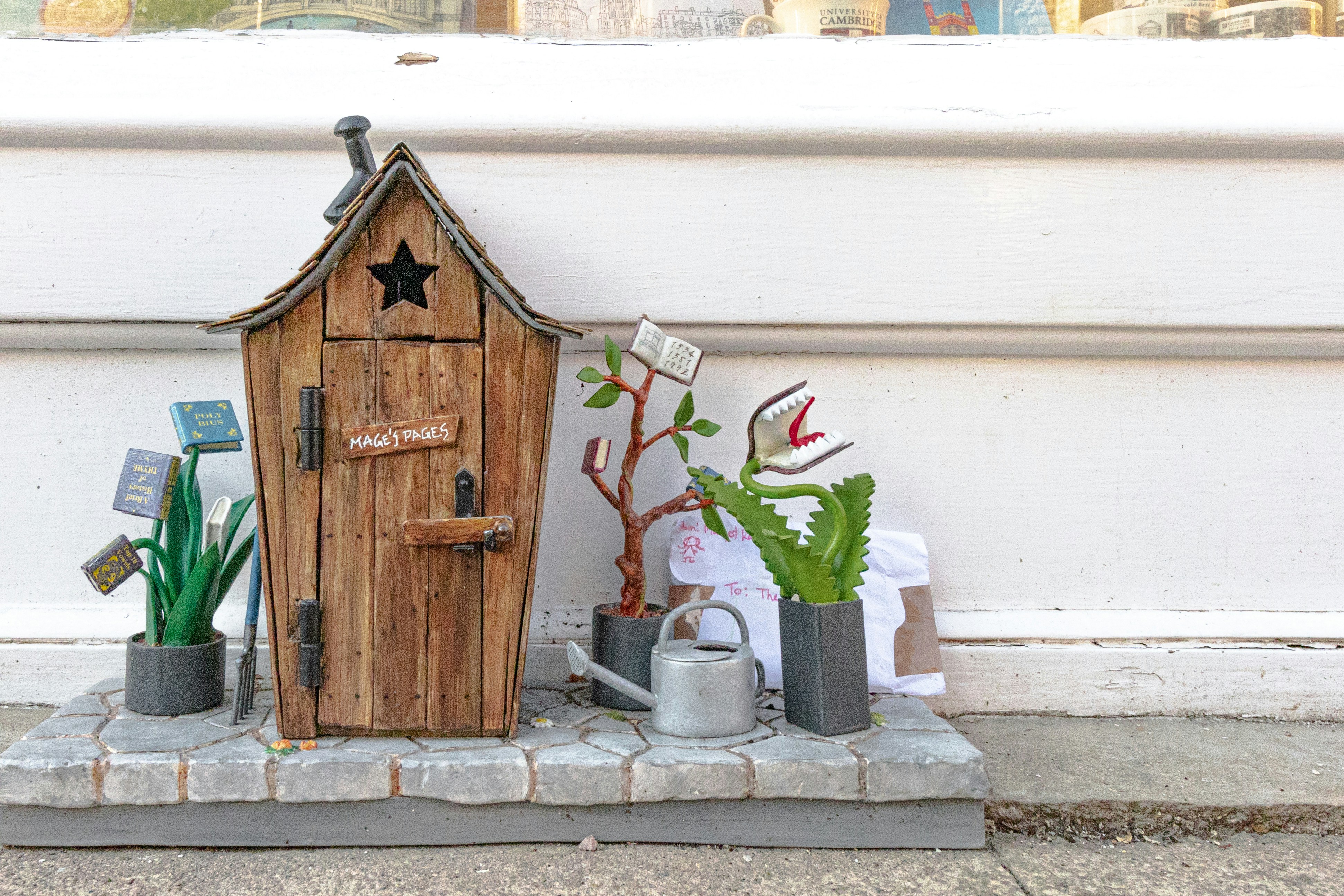 A whimsical garden with a wooden outhouse.