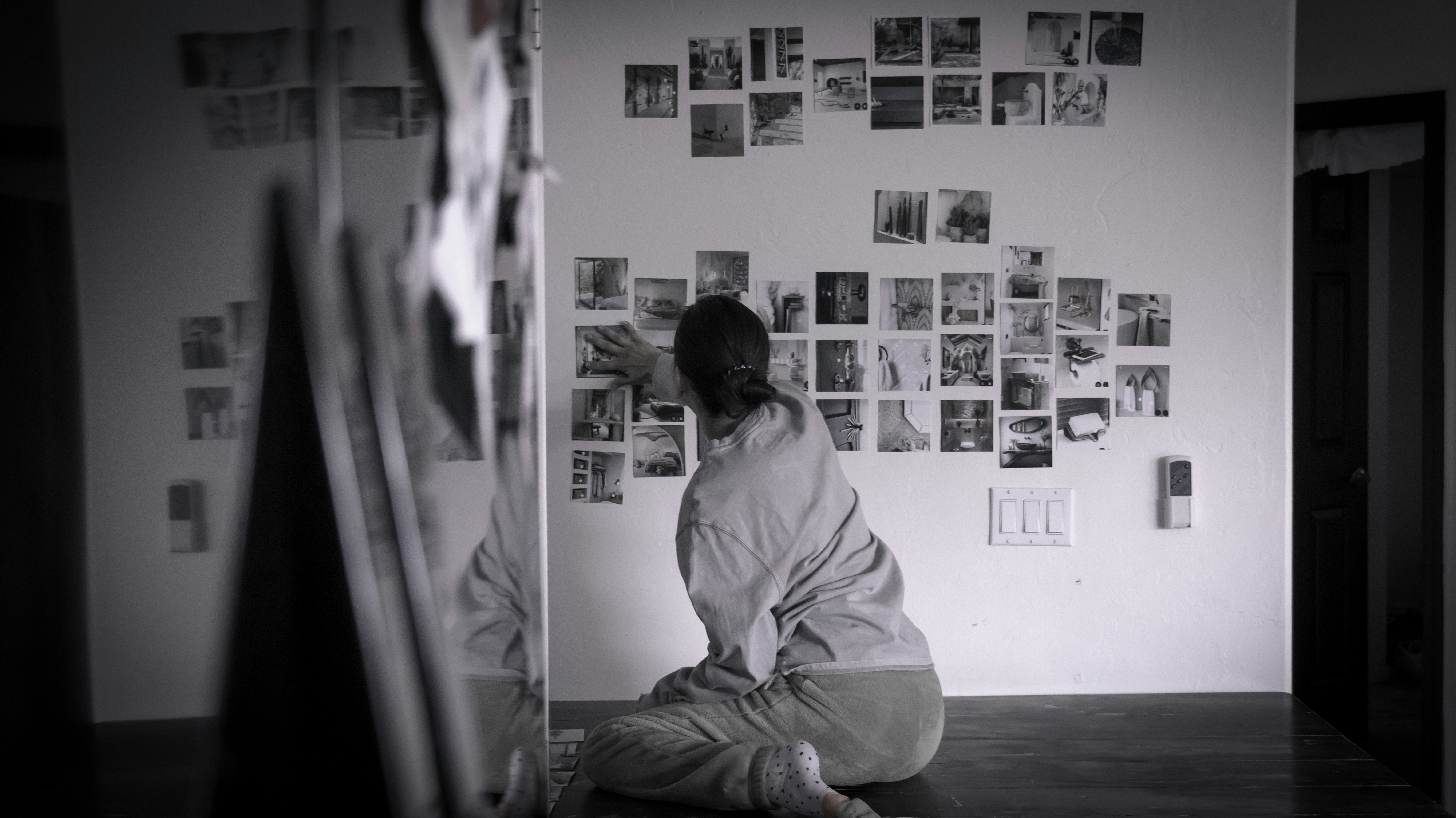 A person looks at photos on the wall.