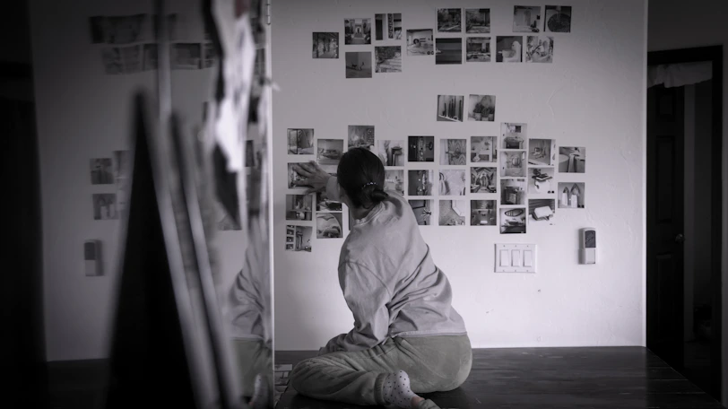 A person looks at photos on the wall