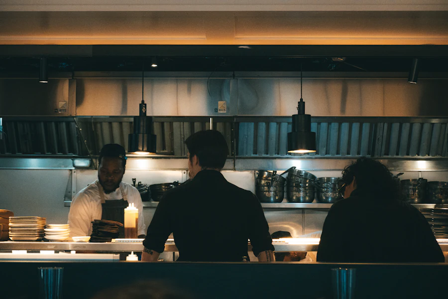Cooks working in a dimly lit restaurant kitchen at night