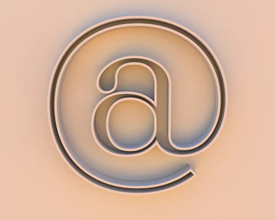 An "at" symbol on a beige background.