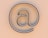 An "at" symbol on a beige background.