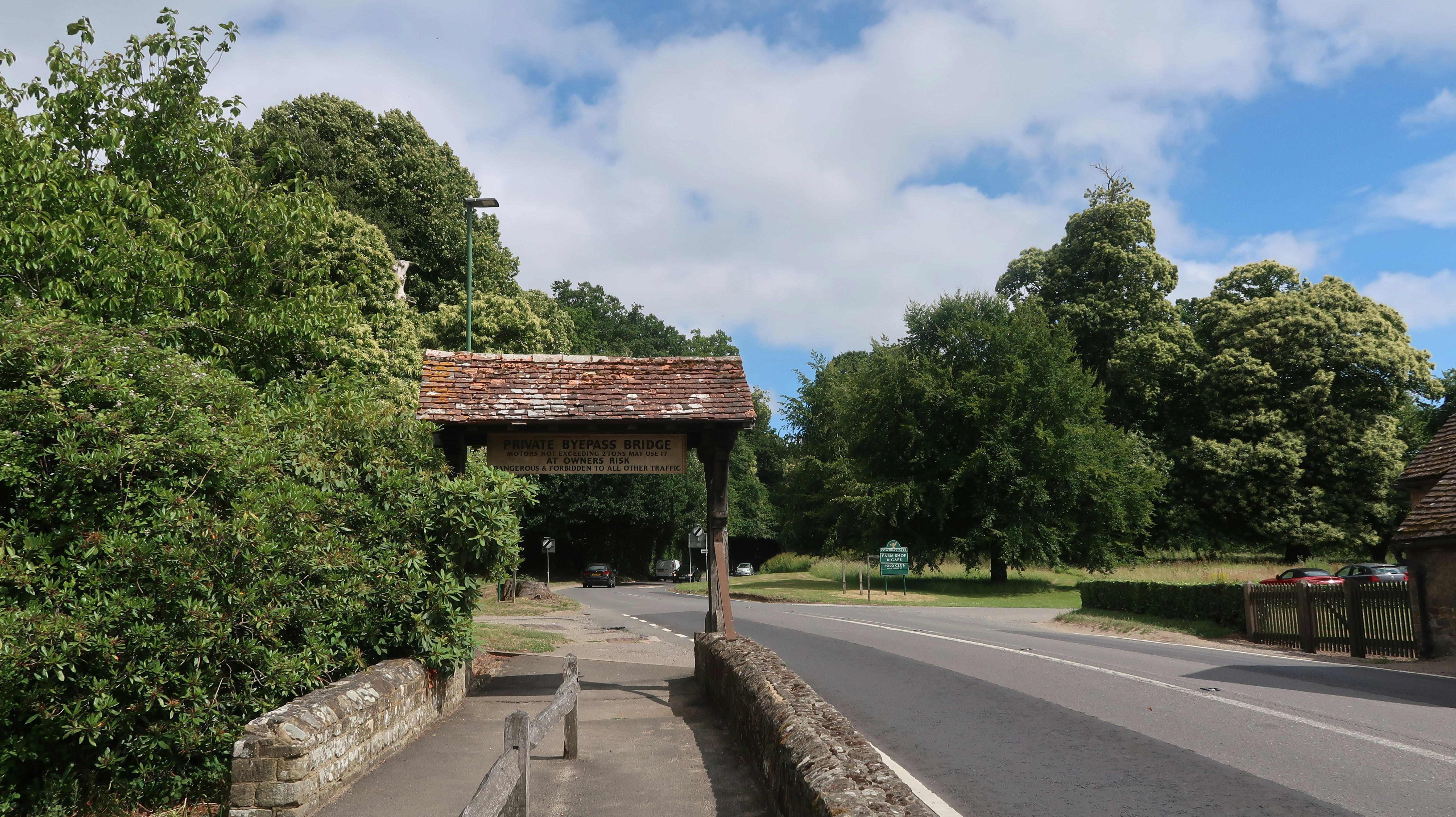 A road leads through a gate surrounded by trees.