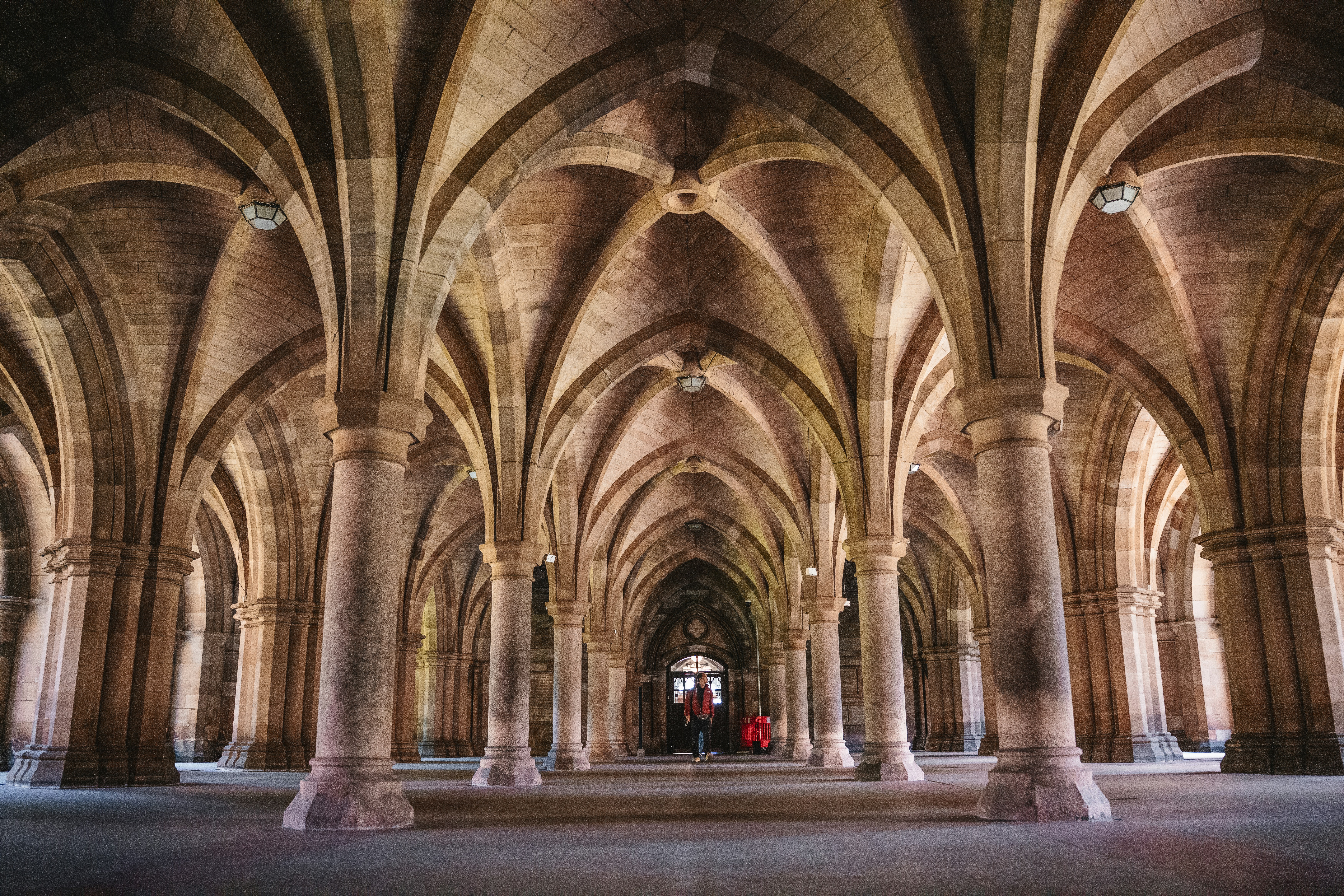A gothic building's arched hallway is visible.