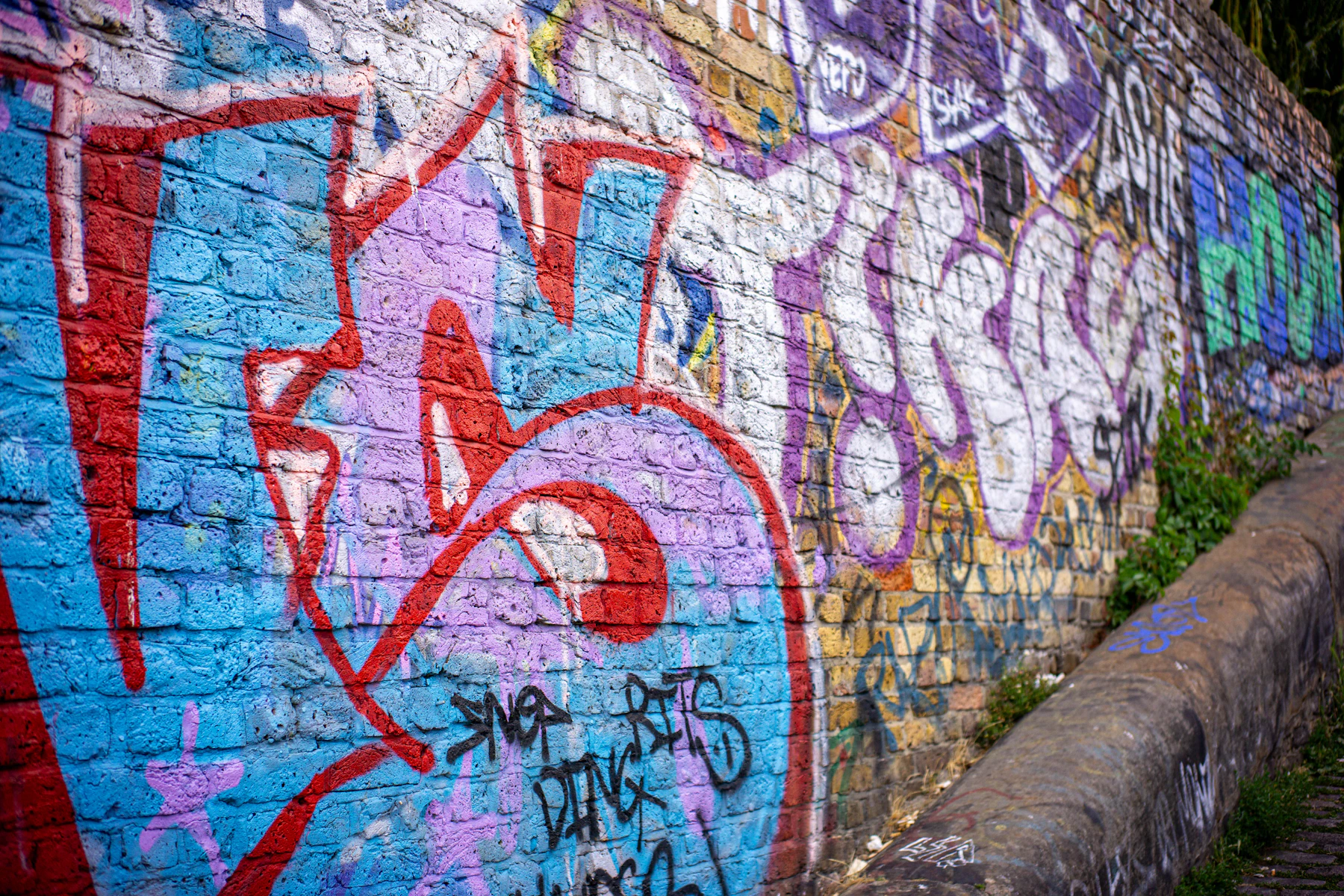 Graffiti peint sur une surface de brique texturée et des joints de mortier