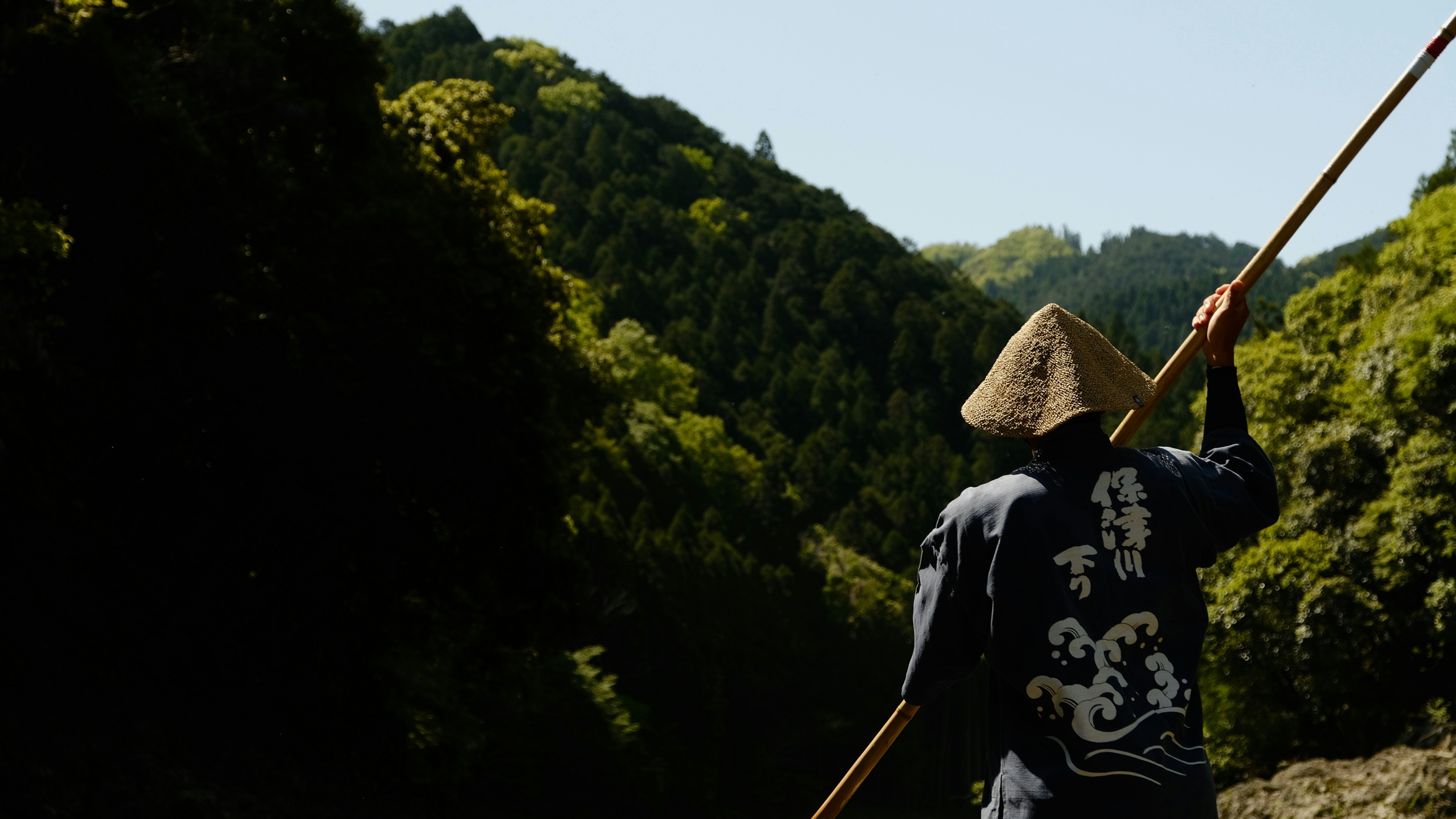 Un homme naviguant paisiblement sur une rivière entourée de verdure illustrant le climat doux de la région.