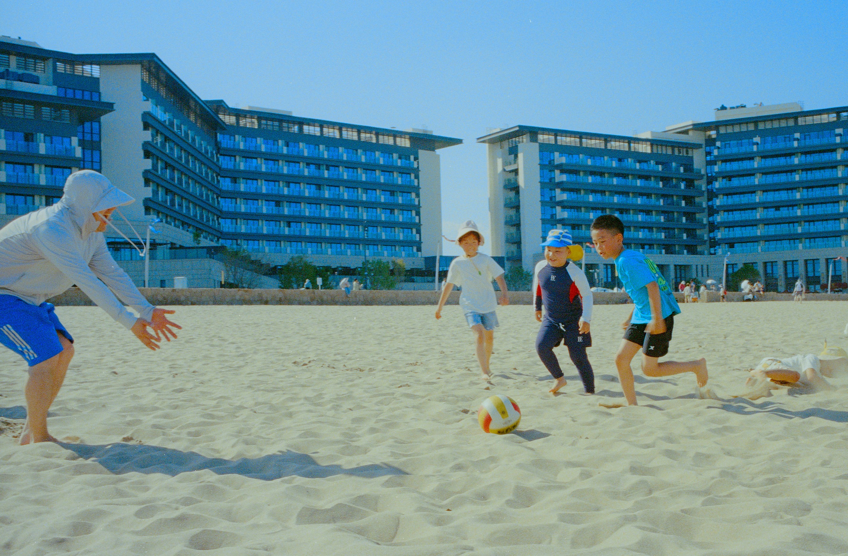 Kids play soccer on a sunny beach