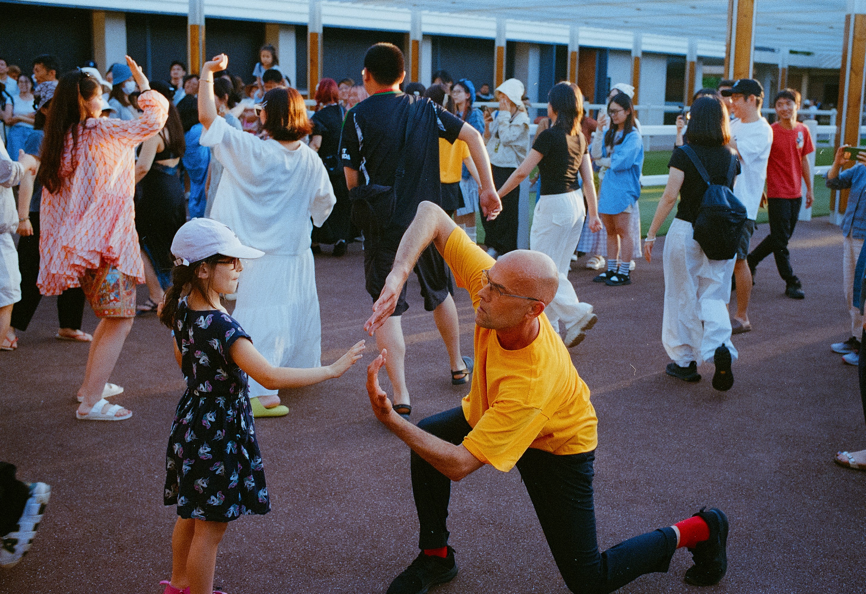People are dancing and having fun outside together.