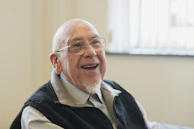 Happy, older man smiles broadly at the camera.