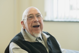 Smiling elderly man with glasses.