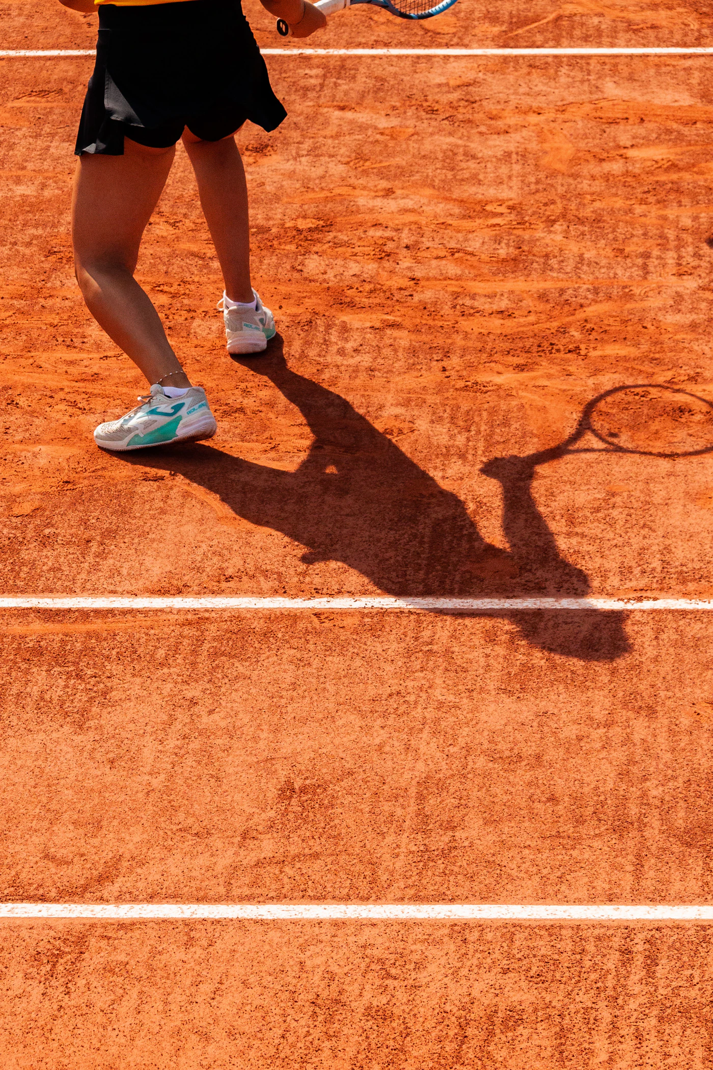 Tennis player on a clay court at Roland Garros.