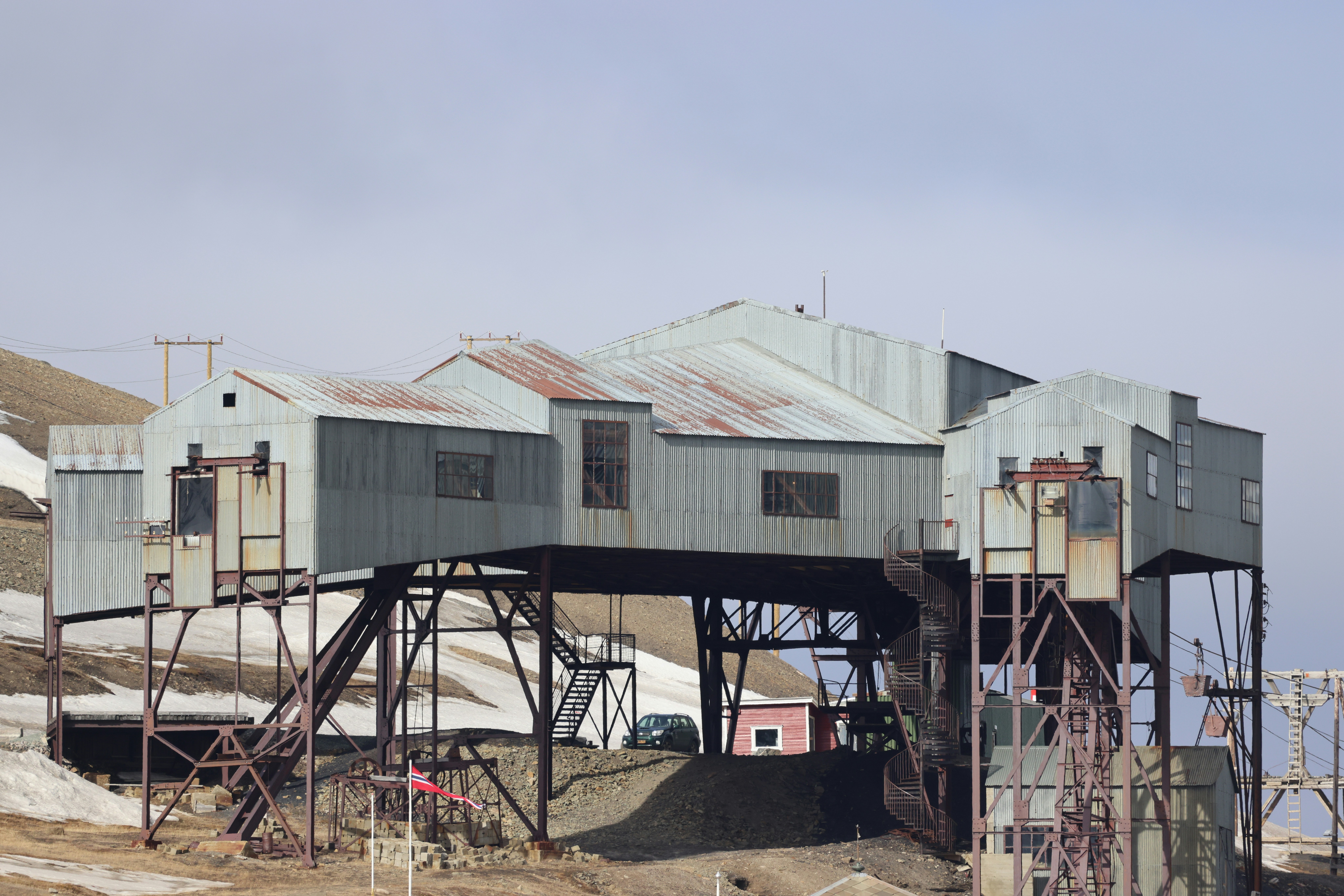 Um antigo edifício industrial fica em uma colina nevada.