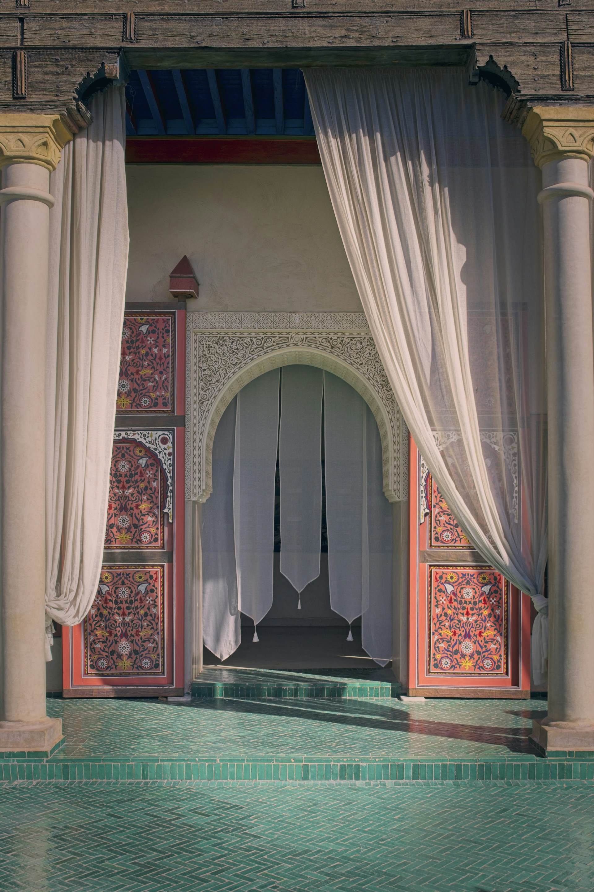 An ornate doorway with curtains leads inside.