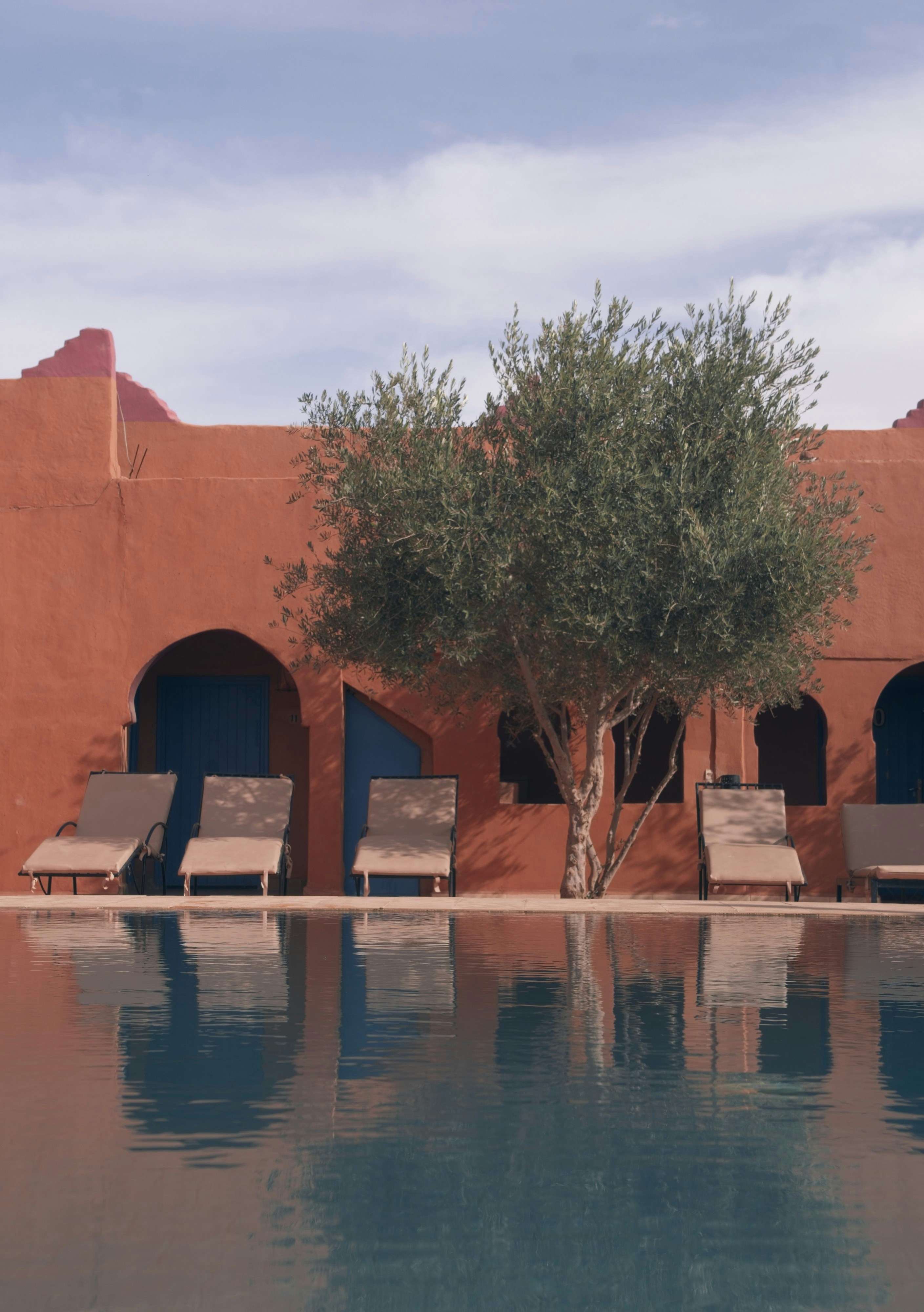 Pool in front of a red building.