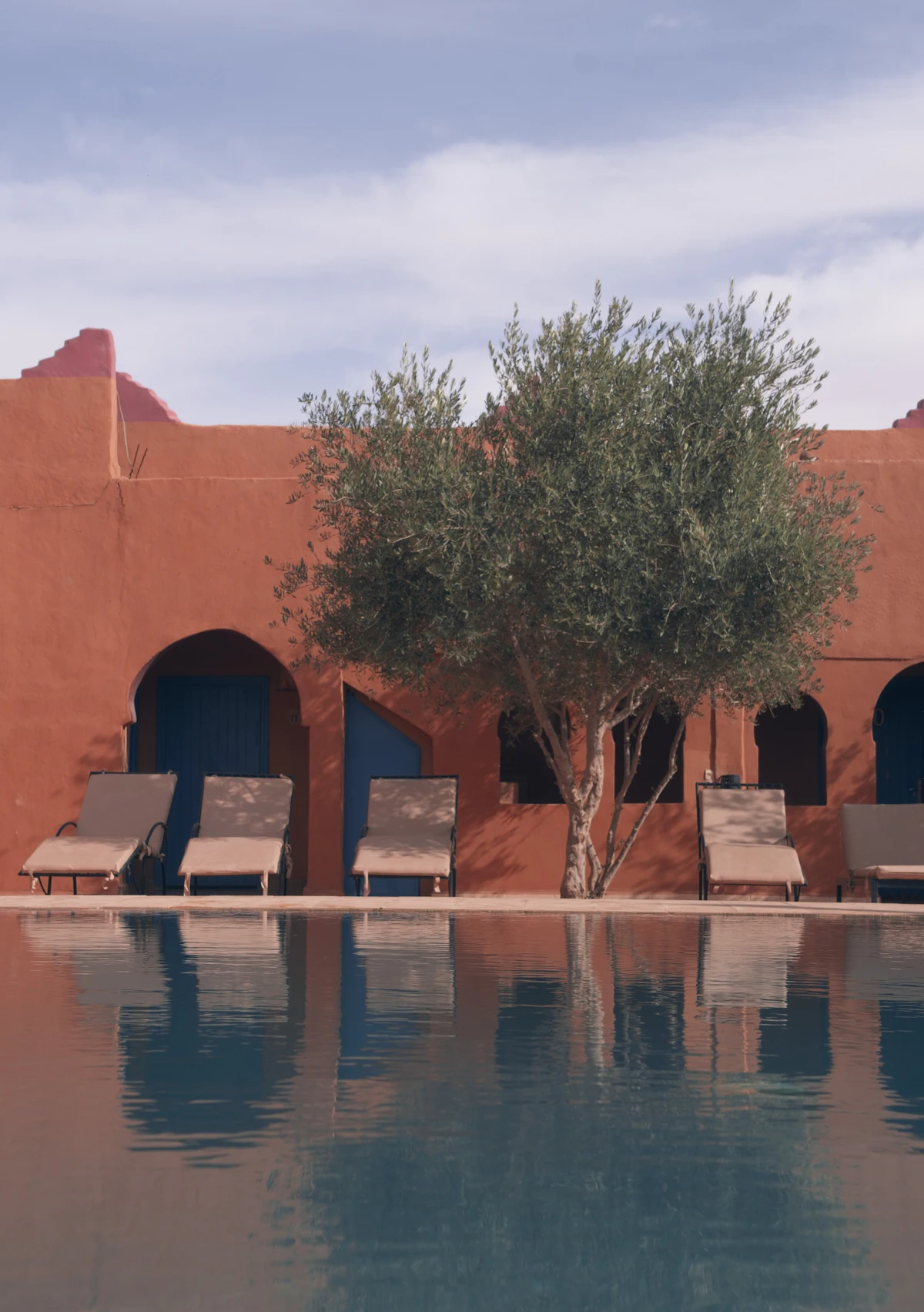 Piscine et architecture ocre sous le ciel bleu du Maroc