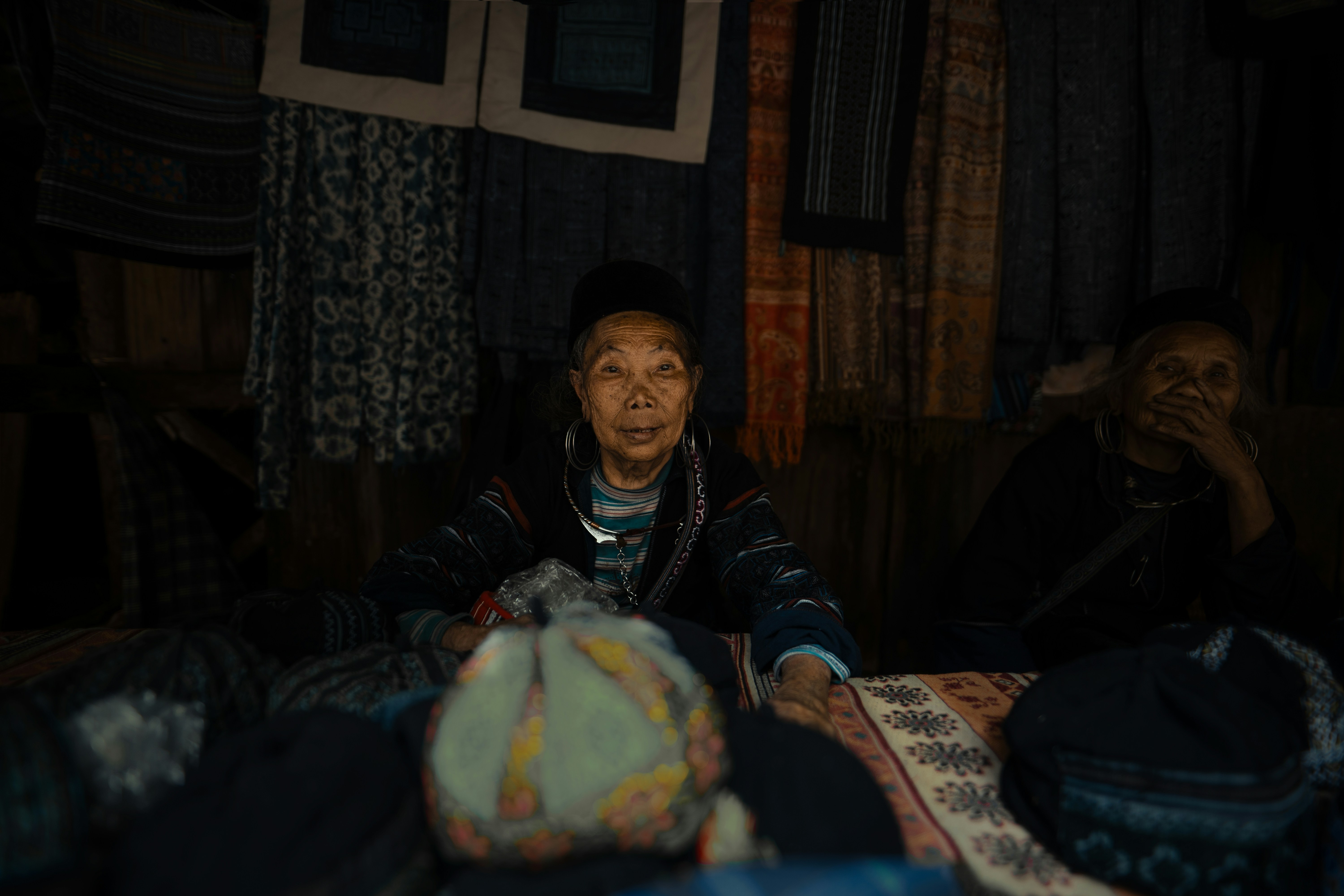 テキスタイルを売る屋台に座っている女性たち。