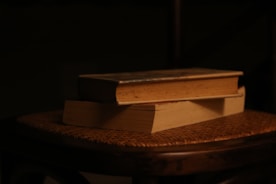 Two books stacked on a wicker chair.