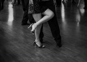 Couple dances close, leg raised high.