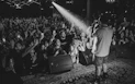 A singer performs on stage to a lively crowd