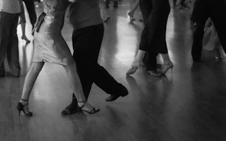 People are dancing on a wooden floor