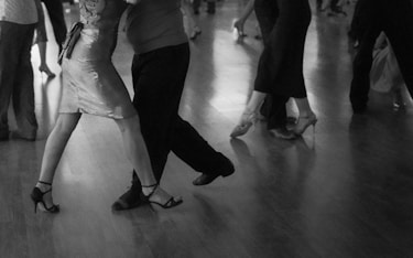 People are dancing on a wooden floor.