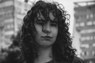 A person poses in front of skyscrapers.