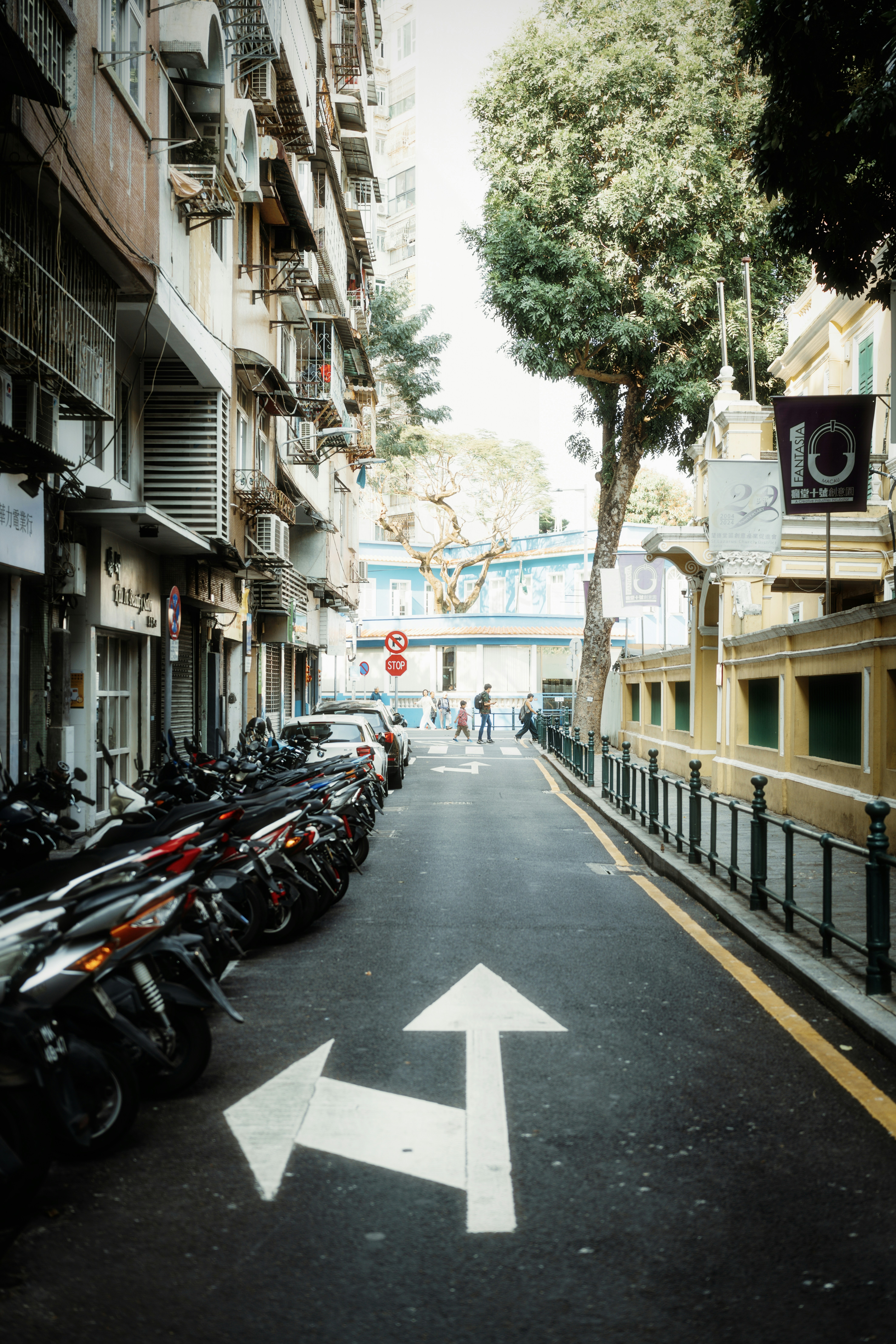Street scene with parked motorcycles and directional arrows.