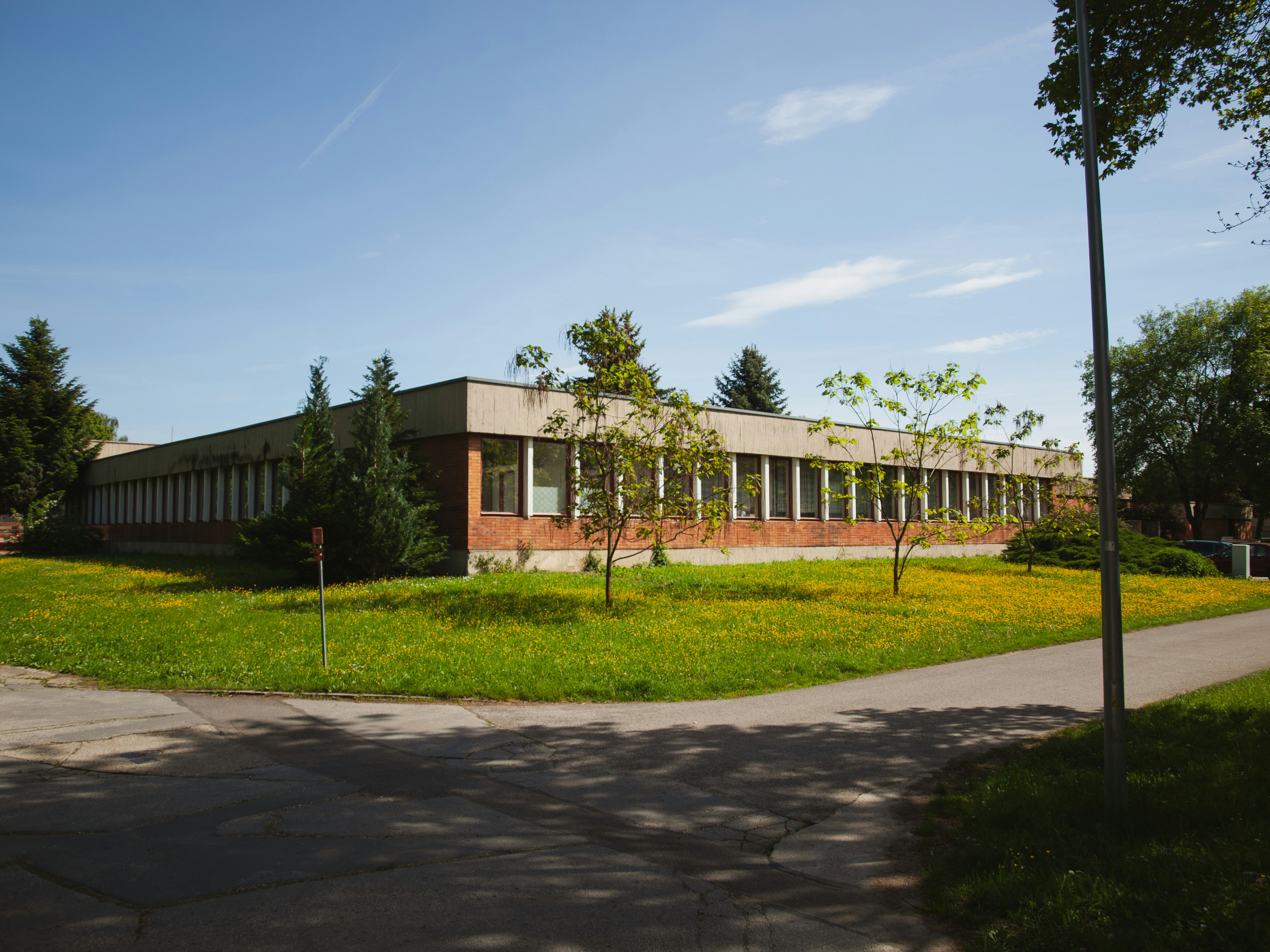 A long, rectangular building sits on a green lawn.