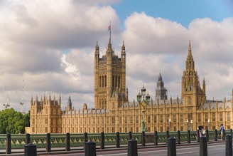 The houses of parliament stand under a cloudy sky.