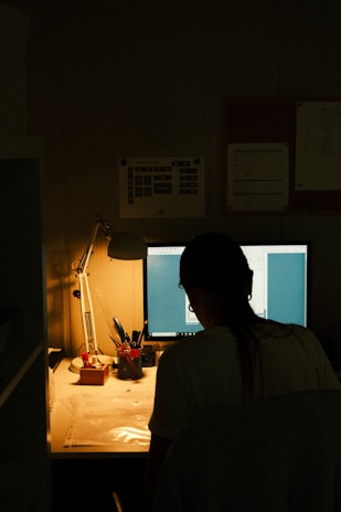 Person working on a computer in a dimly lit room.