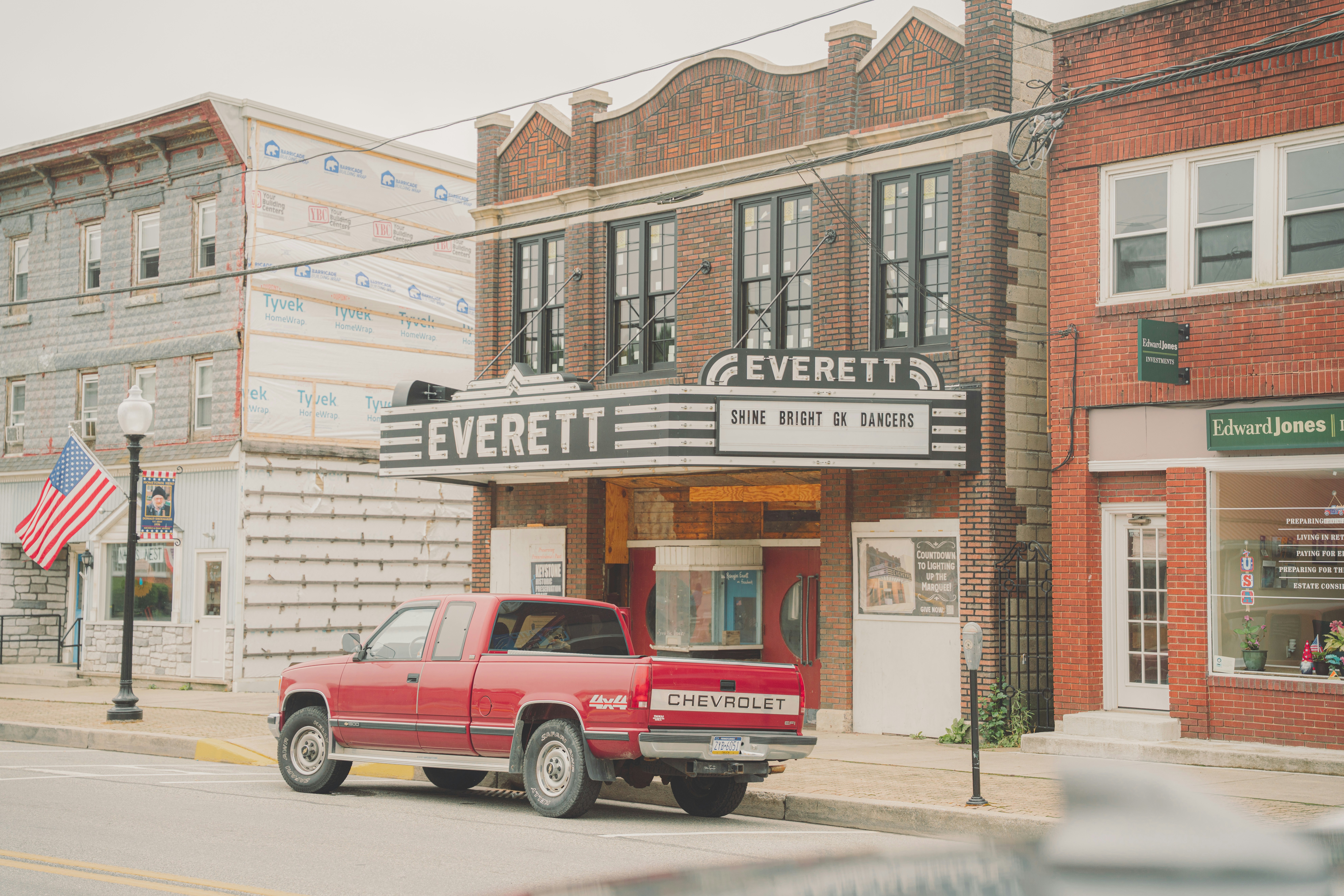 An old theater sits between other buildings.