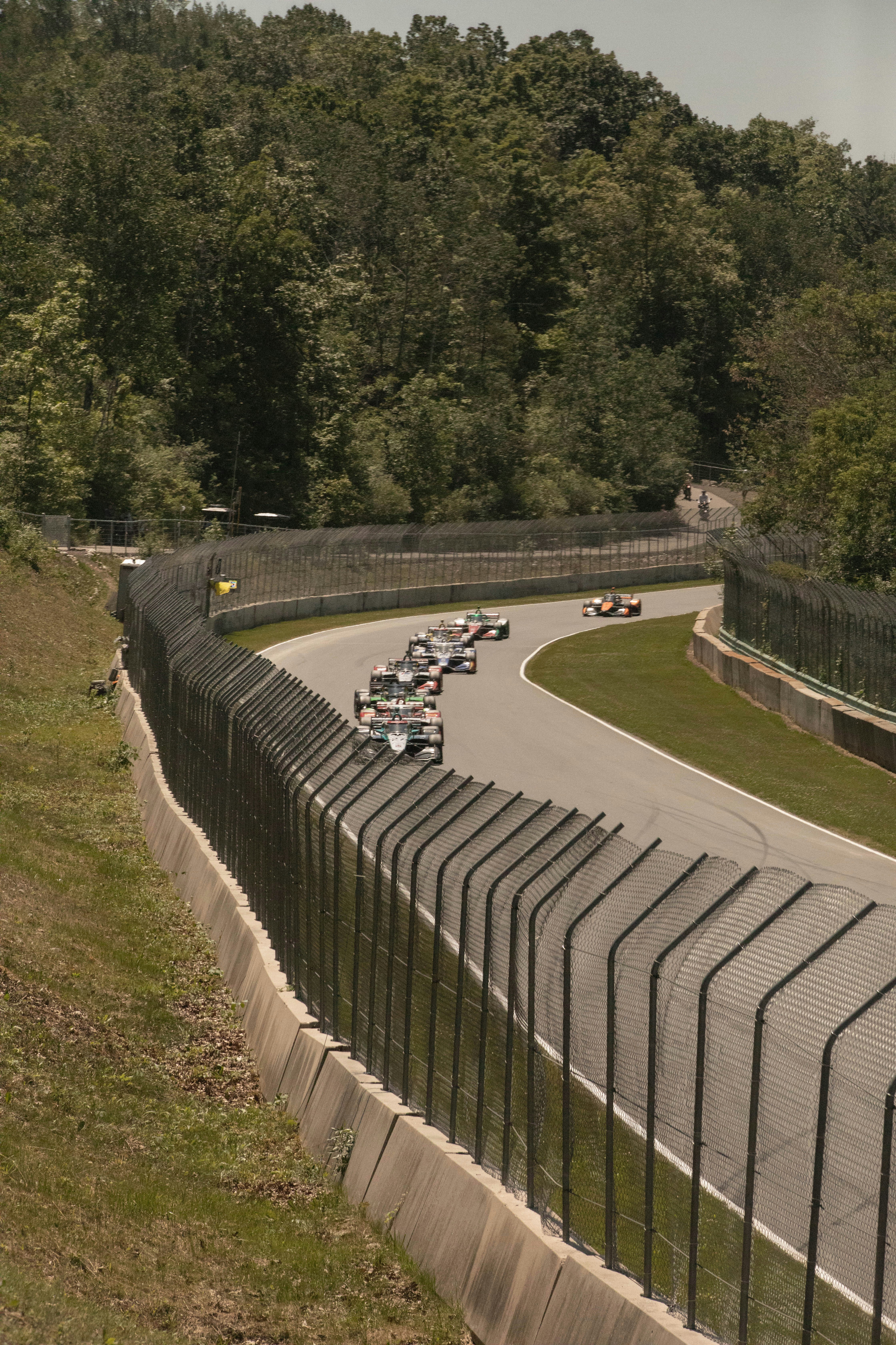 Race cars speed around a winding track.