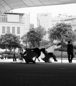 People and sculpture are in an urban landscape.