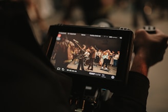 A person records a band performing on stage.