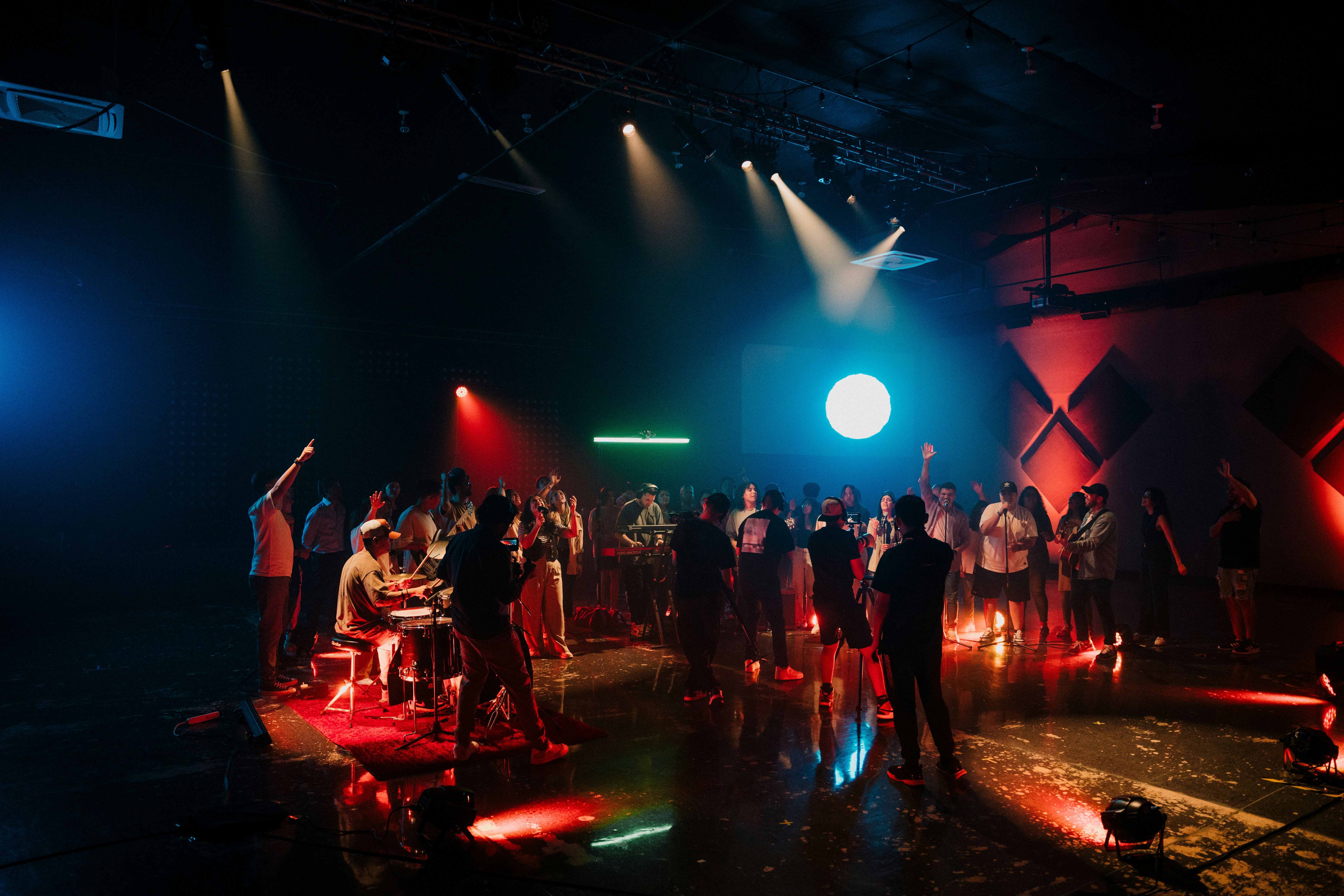 Eine Menschenmenge versammelt sich unter Bühnenlicht.