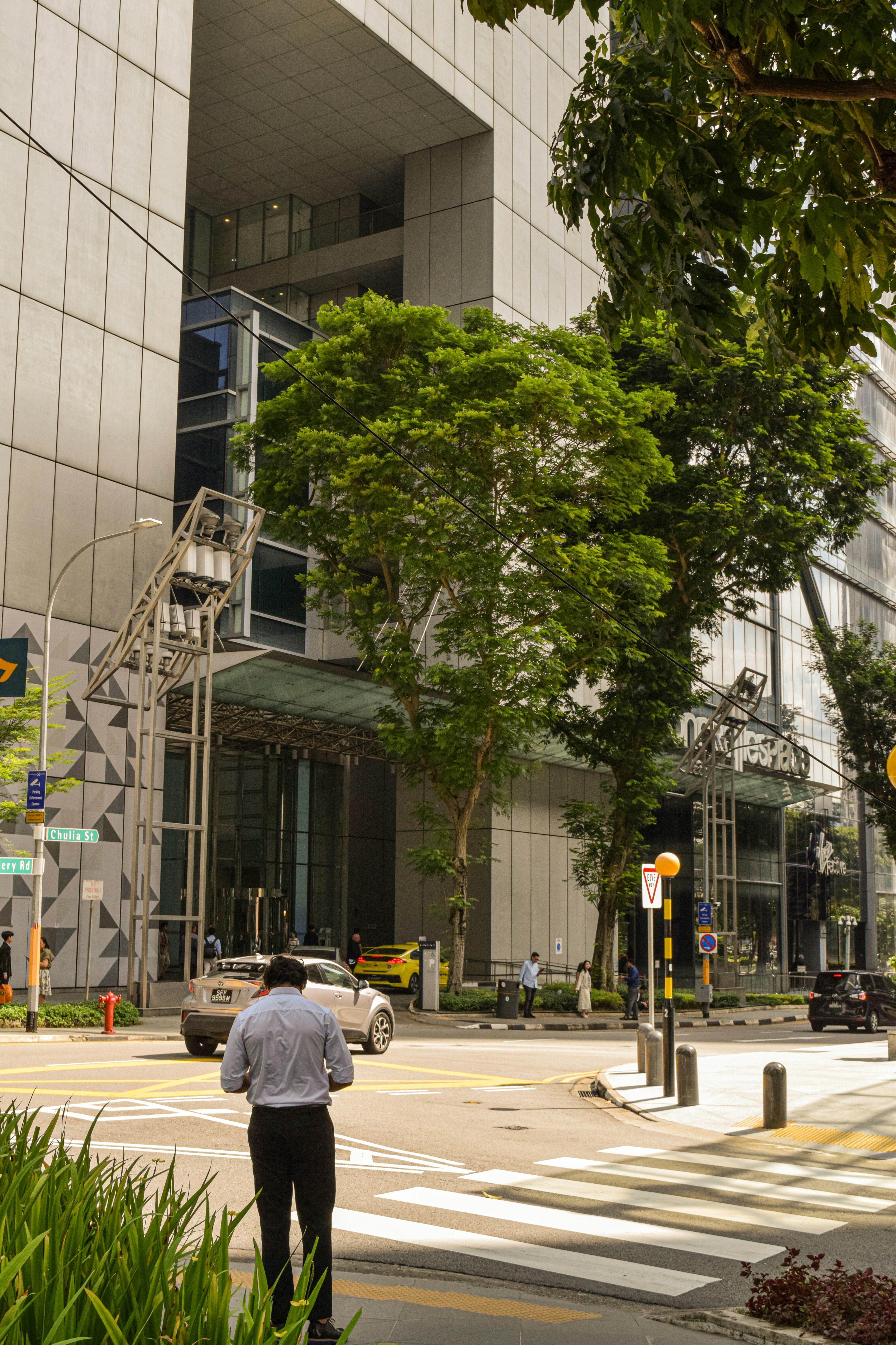 Man stands near a modern, glass building.