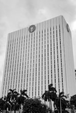 A tall bank building with palm trees.