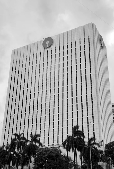 A tall bank building with palm trees.