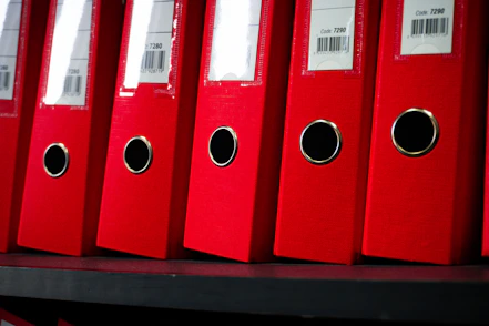 Office Red file folders are neatly arranged on a shelf.