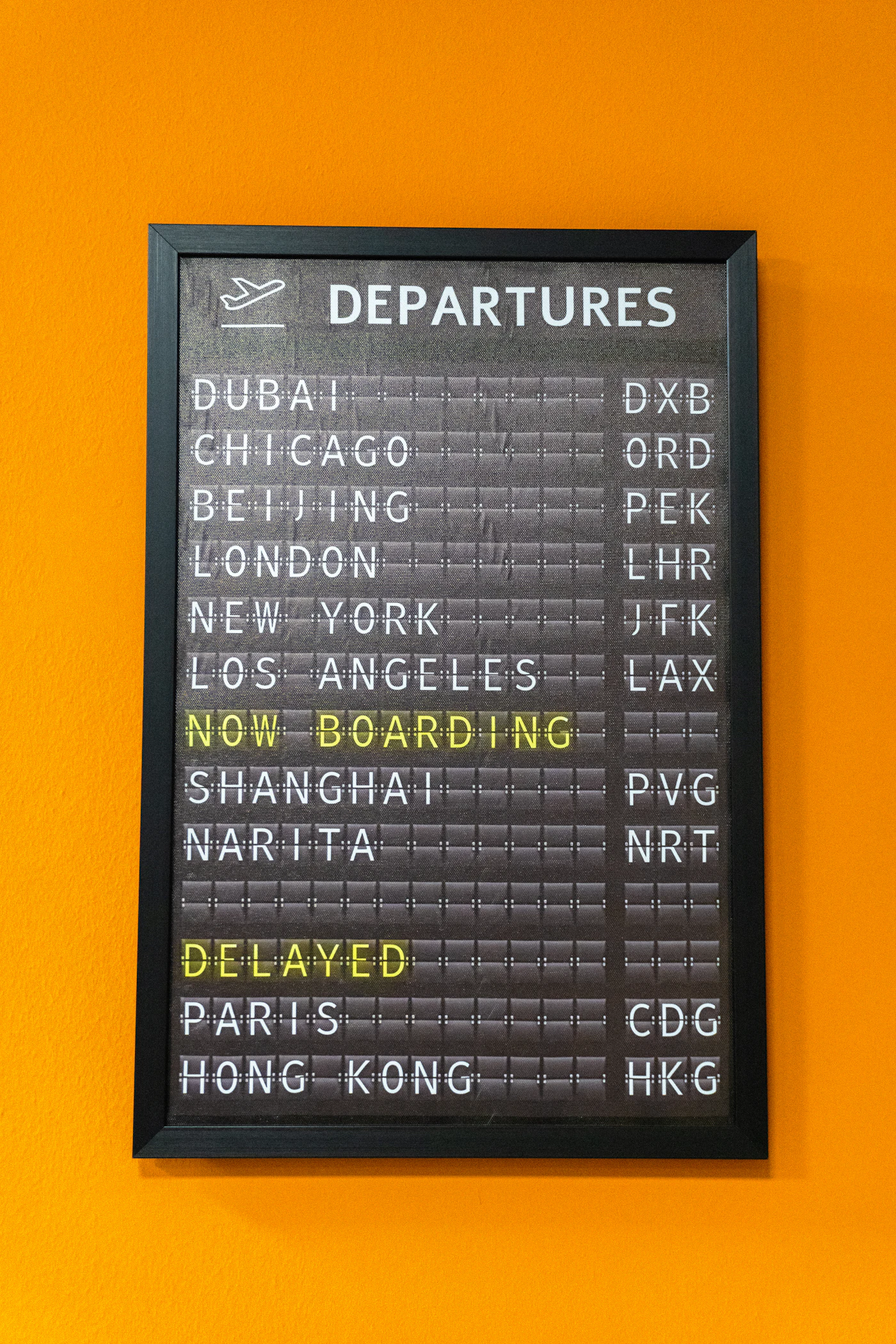 A green airport departure board listing flight information at a terminal