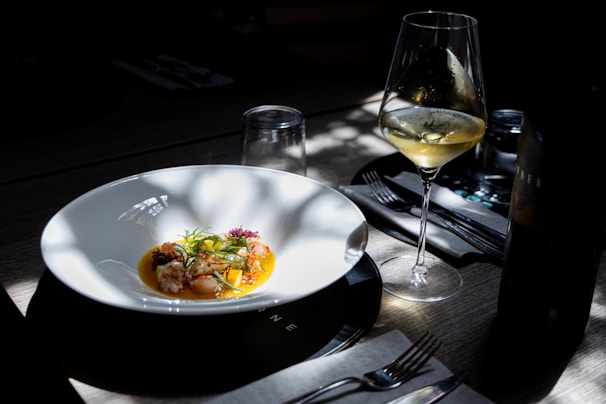 A beautiful meal is served with a glass of wine.