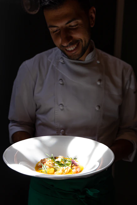 Chef proudly presents a delicious italian plate of food.