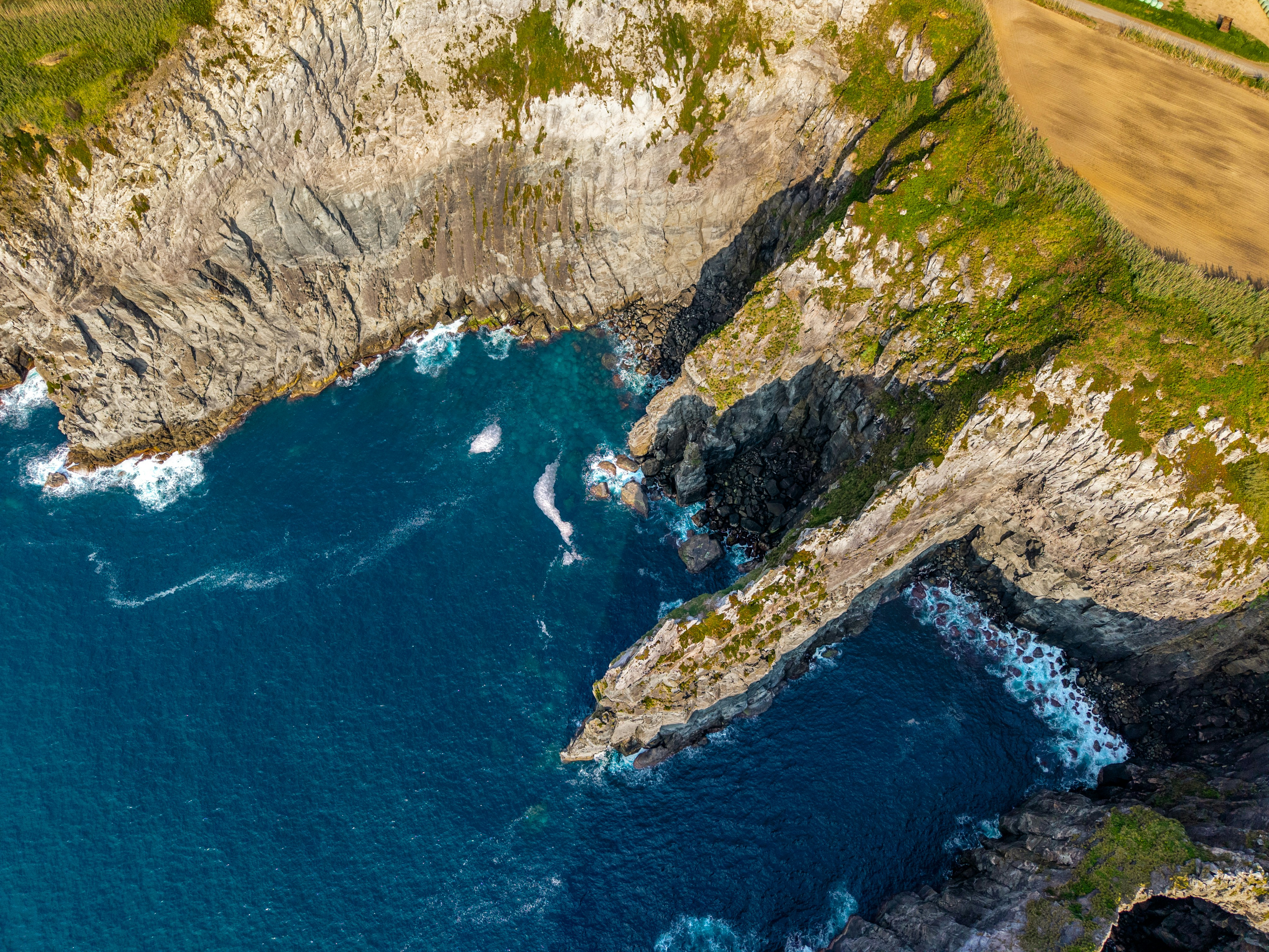 Rocky cliffs meet the blue ocean waters.