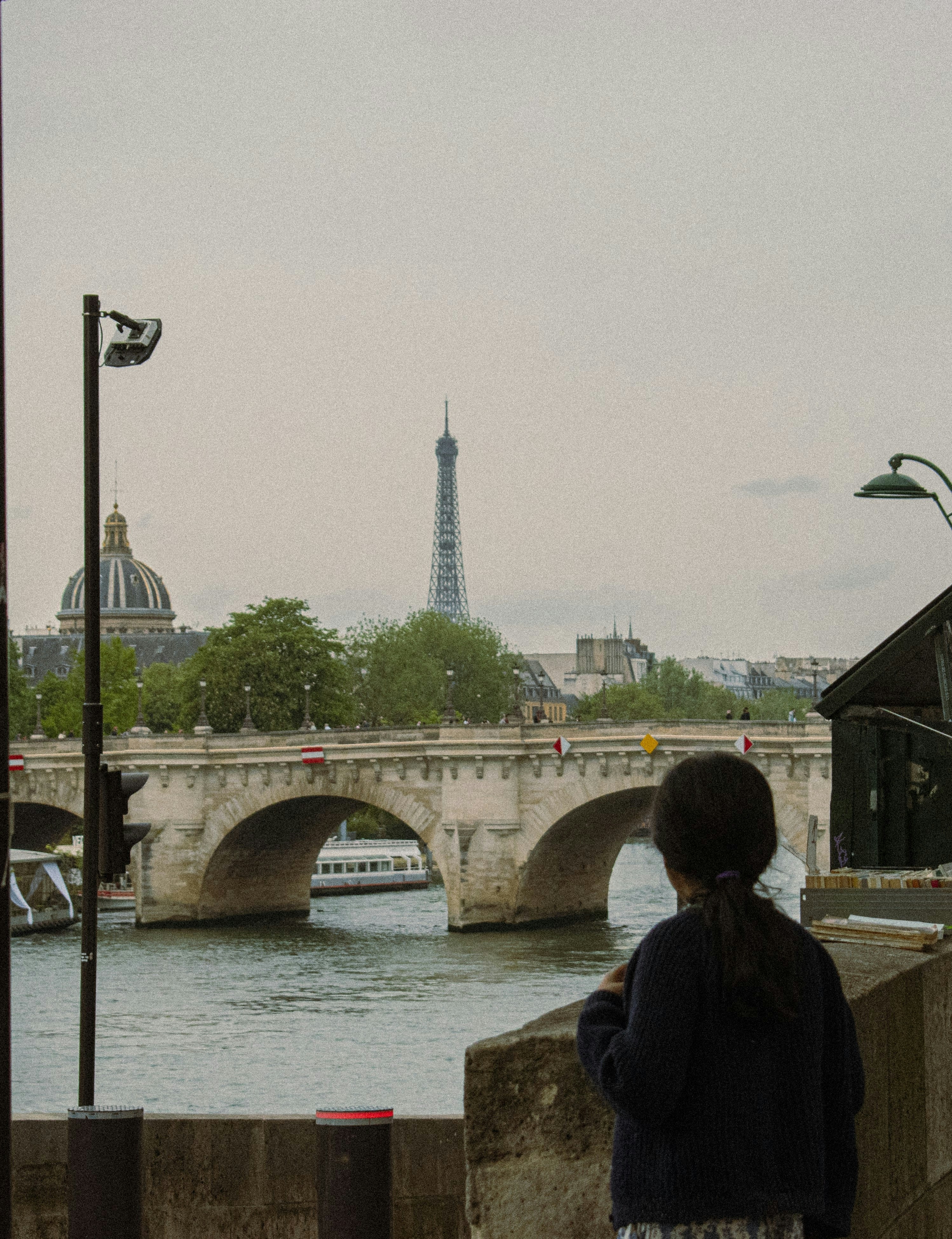 Seseorang menatap menara dan jembatan Eiffel Paris.