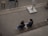 Two people sit on a bench, viewed from above.