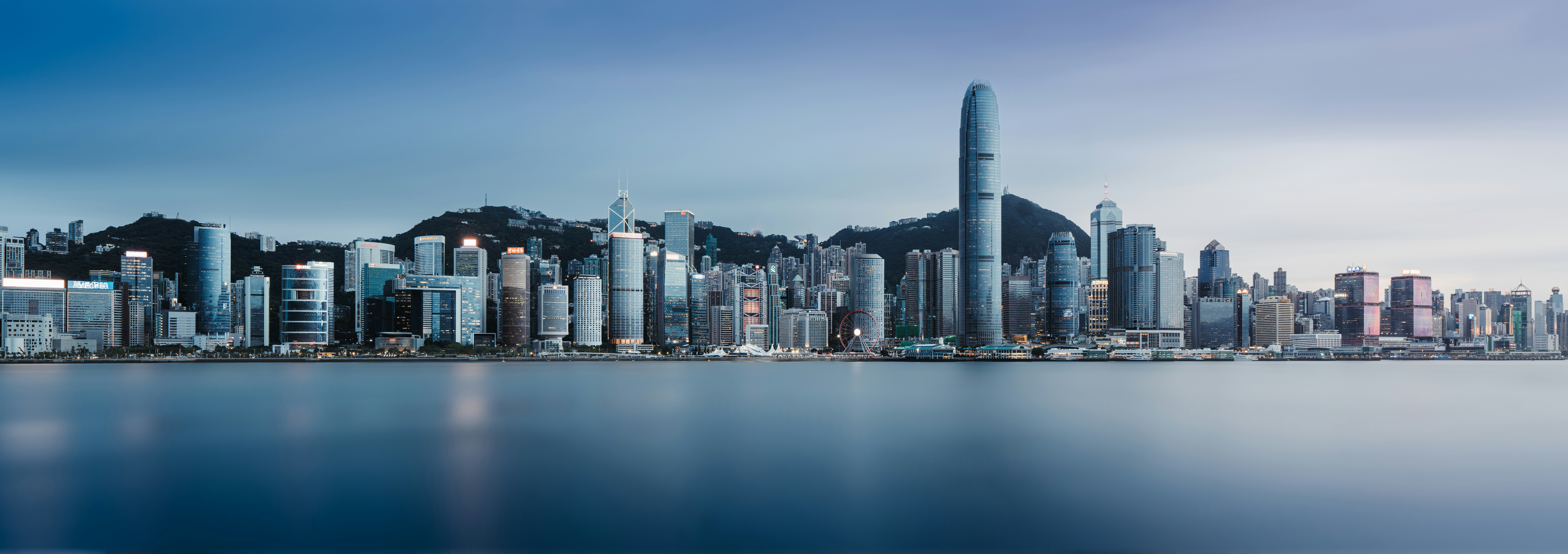 A modern city skyline over calm water.